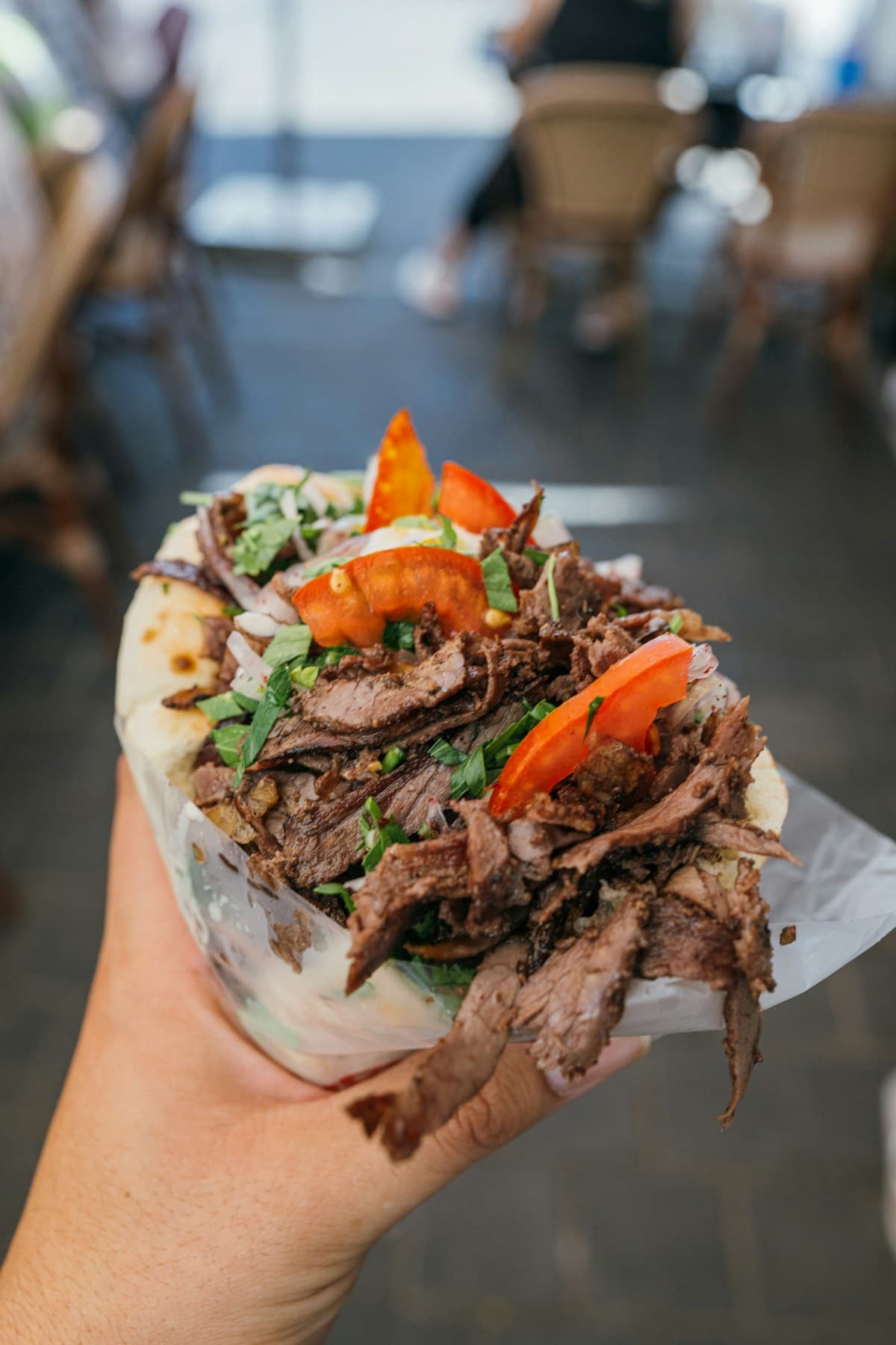 Un döner kebab garni de viande, salade, tomate et sauce blanche